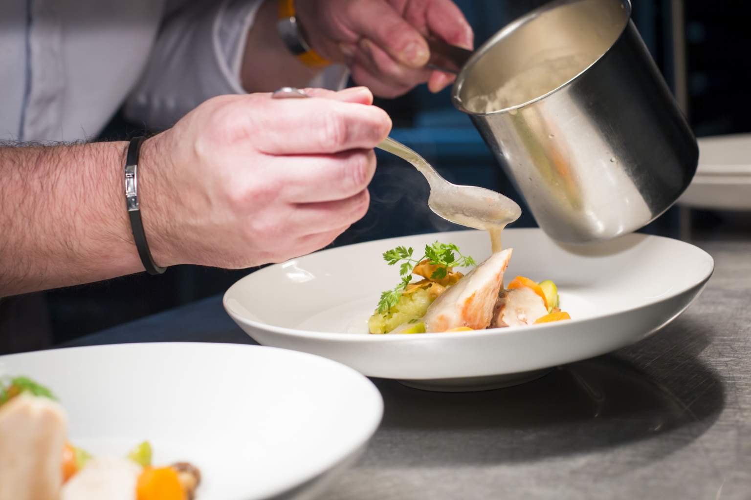 Le Chef Jérôme Raymond qui dresse un plat au restaurant de l'Hôtel du Morvan, Hôtel Restaurant à Luzy, dans la Nièvre